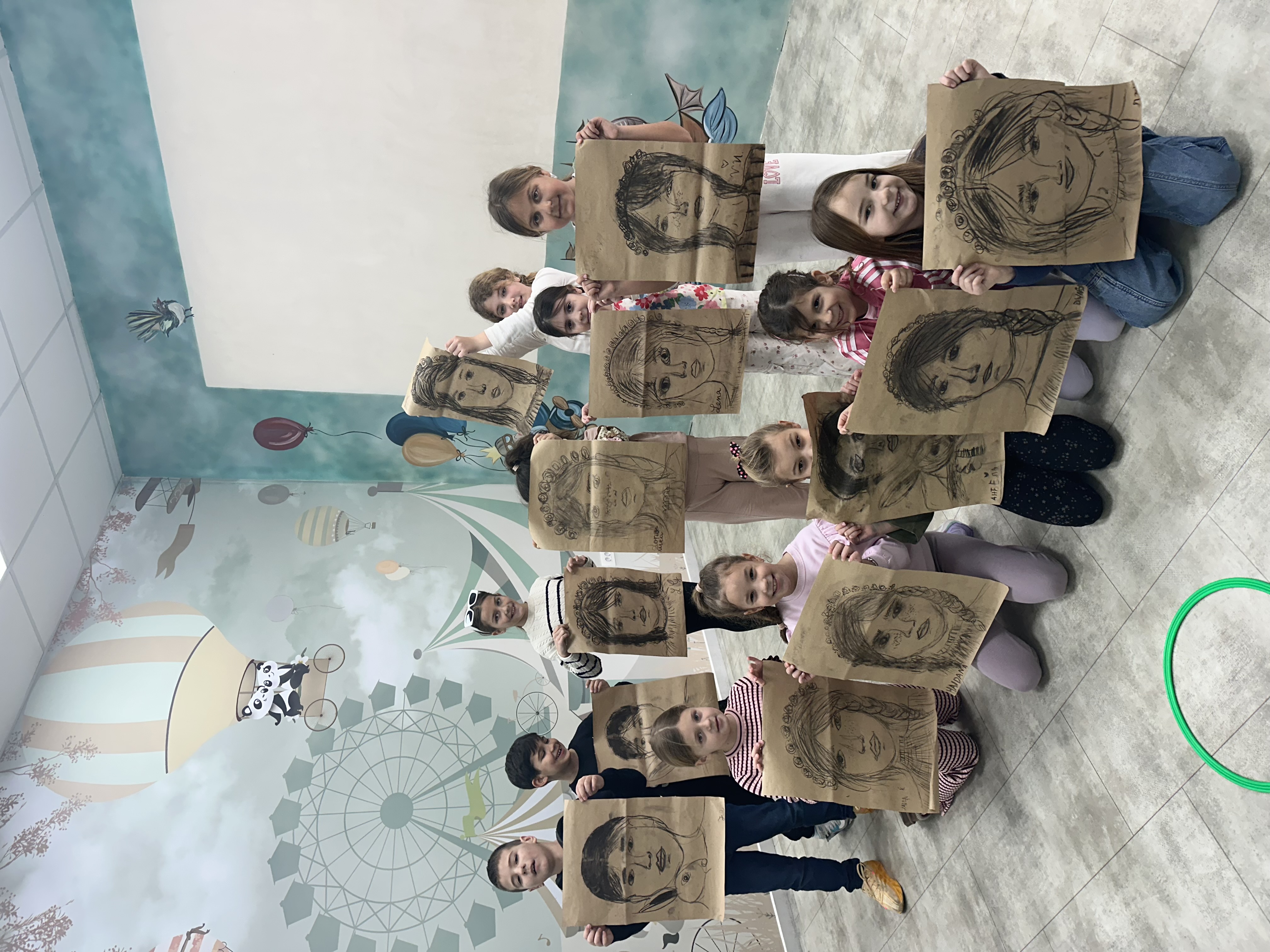 Children with portrait drawings on craft paper